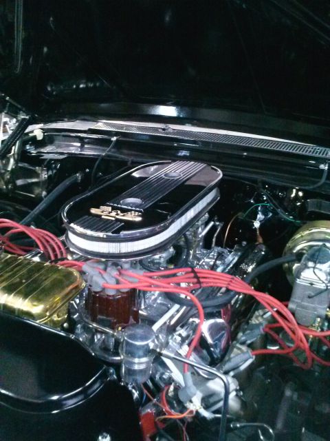 1960 Ford Falcon - Close-up view of a polished engine bay a chrome air cleaner and prominent red spark plug wires.