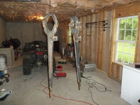 1995 Ford Bronco - Two large metal parts hanging in a garage, with an ATV visible in the background.