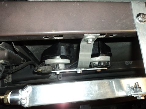 2004 Mercury Grand Marquis - Close-up view of aftermarket horns installed in the front of a vehicle.