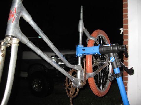 1994 Ford Bronco - A bicycle frame is mounted on a repair stand, with an orange tire visible in the background.