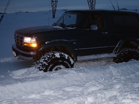1996 Ford Bronco - Ford Bronco is stuck in the snow, with only the front wheel visible.