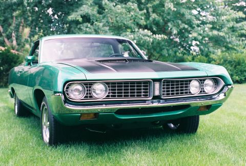 1971 Ford Ranchero - A green Ford Ranchero with a black hood stripe sits on a grassy lawn.