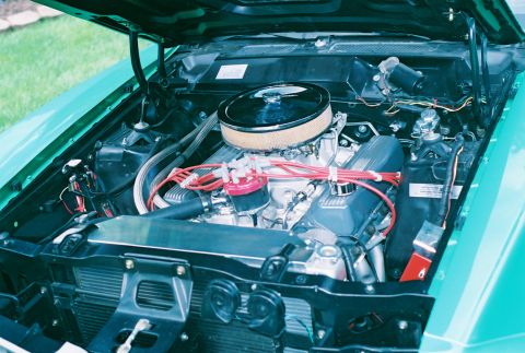 1971 Ford Ranchero - The engine bay of a teal-colored vehicle is open, revealing the V8 engine and its components.
