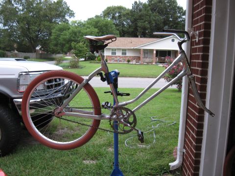 1994 Ford Bronco - A bicycle frame is mounted on a repair stand, with a portion of a white truck visible in the background.