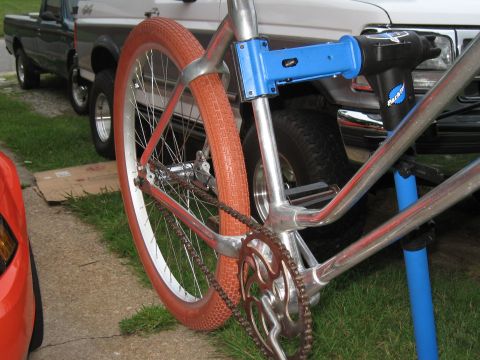 1994 Ford Bronco - A bicycle is mounted on a blue repair stand, with two trucks visible behind it.