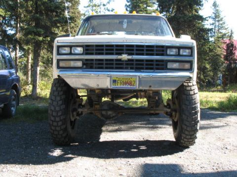 1989 Chevrolet C/K Pickup - This lifted 1989 Chevrolet C/K Pickup features a prominent grille and large off-road tires.