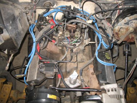1989 Chevrolet C/K Pickup - The engine bay of a 1989 Chevrolet C/K Pickup shows a complex arrangement of wires and engine components.