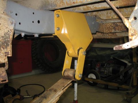 1989 Chevrolet C/K Pickup - Close-up of a yellow lift assist mechanism mounted to a vehicle's frame.