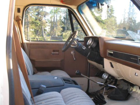 1989 Chevrolet C/K Pickup - Interior view of a pickup truck, showing the dashboard, seats, and gear shifter.