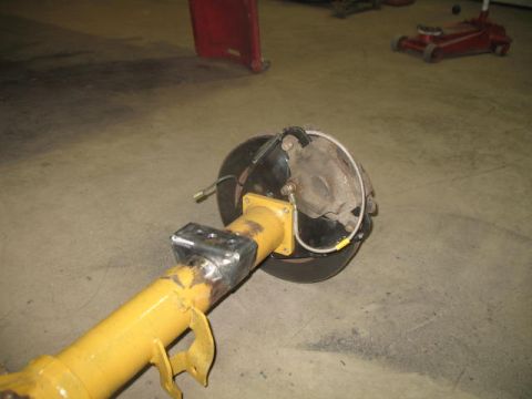 1989 Chevrolet C/K Pickup - Close-up of a rear axle assembly, showing the brake caliper and painted components.