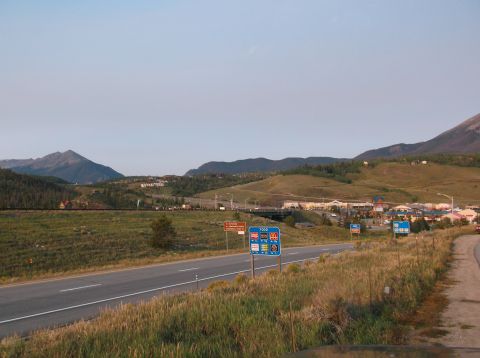 2009 Kenworth T800 - Mountain landscape with a highway and distant town under a clear sky.