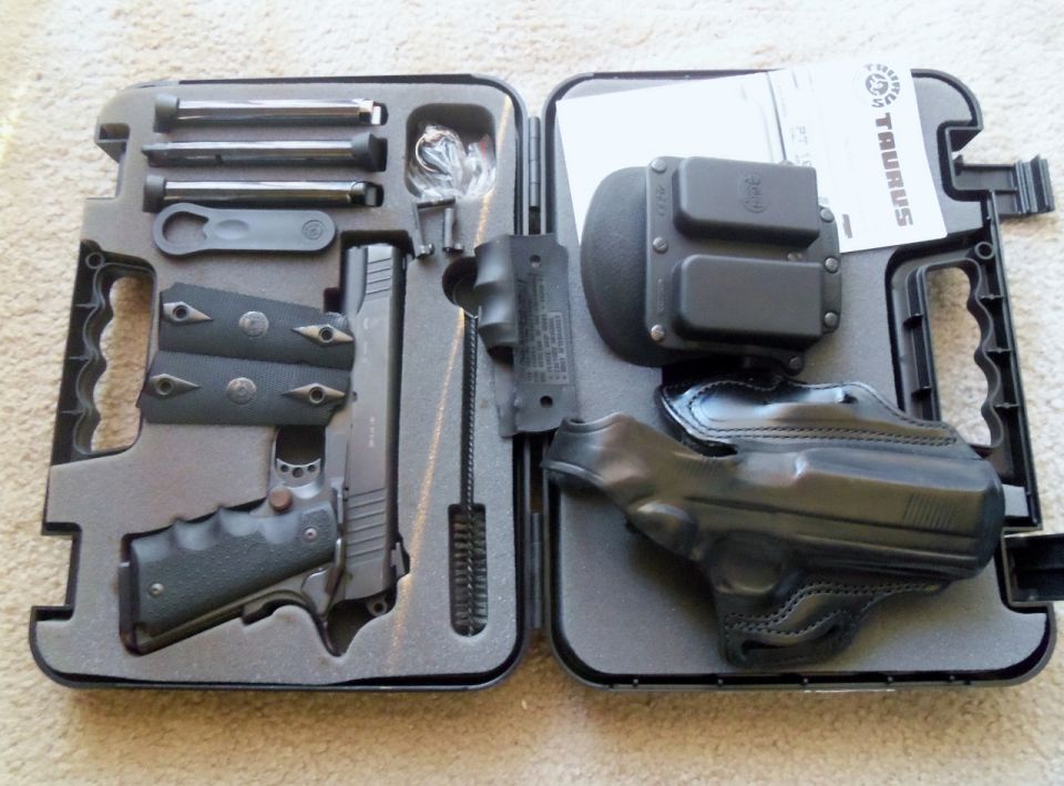 Pistol, magazines, holster, and cleaning tools in a black case