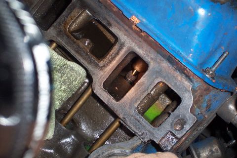 1980 Ford Bronco - Close-up view of an engine's intake manifold, showing internal components and a small amount of green fluid.