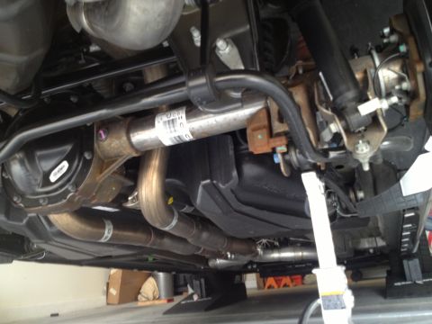 2013 Ford Mustang - The underside of a vehicle is shown, focusing on the exhaust system and rear axle assembly.