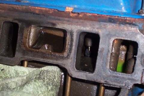 1980 Ford Bronco - Engine intake manifold ports showing internal components and fluid residue.