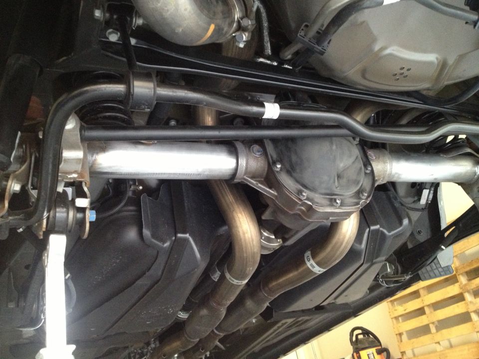 Underside view of a rear axle, differential, dual exhaust pipes, and fuel tank