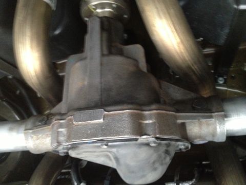 2013 Ford Mustang - Close-up view of the rear differential and exhaust system components of a vehicle.