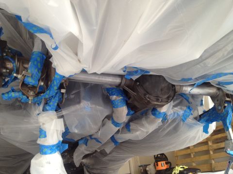 2013 Ford Mustang - The vehicle's undercarriage components are masked off, likely in preparation for painting or detailing.