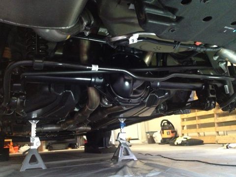 2013 Ford Mustang - The rear suspension and axle assembly of a 2013 Ford Mustang are visible, supported by jack stands.