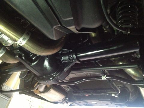 2013 Ford Mustang - The underside of a vehicle reveals its rear axle and exhaust components, with a "SUPERMOTORS" logo visible.