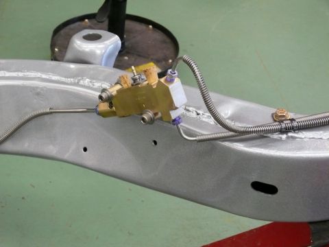 1976 Chevrolet Corvette - Close-up of a brake proportioning valve and lines mounted on a vehicle's frame.