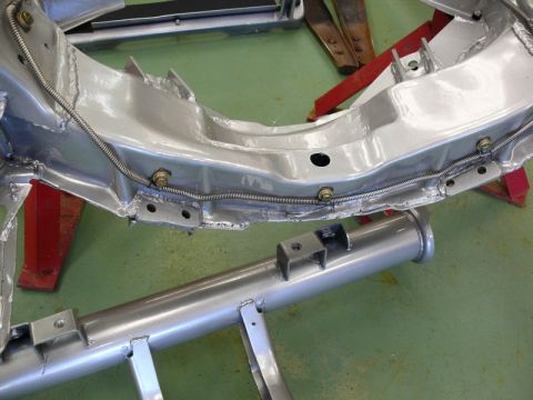 1976 Chevrolet Corvette - Close-up view of a Corvette chassis frame, showing brake lines and exhaust pipe components.