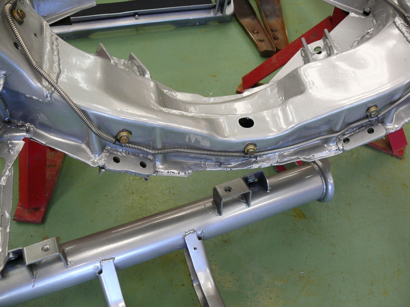 Corvette chassis frame with brake lines and exhaust pipe