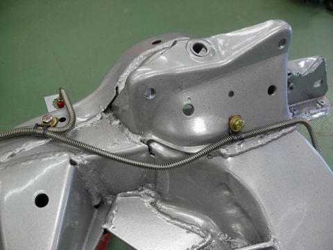 1976 Chevrolet Corvette - A close-up view of a vehicle's chassis component, showing welded seams and mounting hardware.