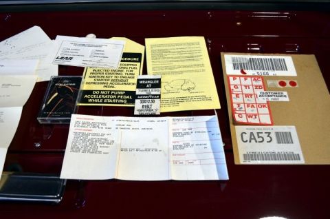 1995 Ford Bronco - Collection of vehicle paperwork and a Ford audio systems cassette tape laid out on a car's interior surface.