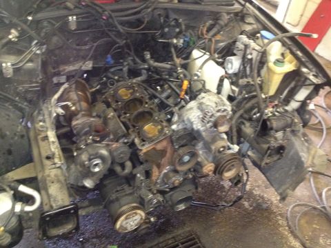 1989 Ford Bronco - The engine has been removed from the vehicle, leaving the engine bay exposed.