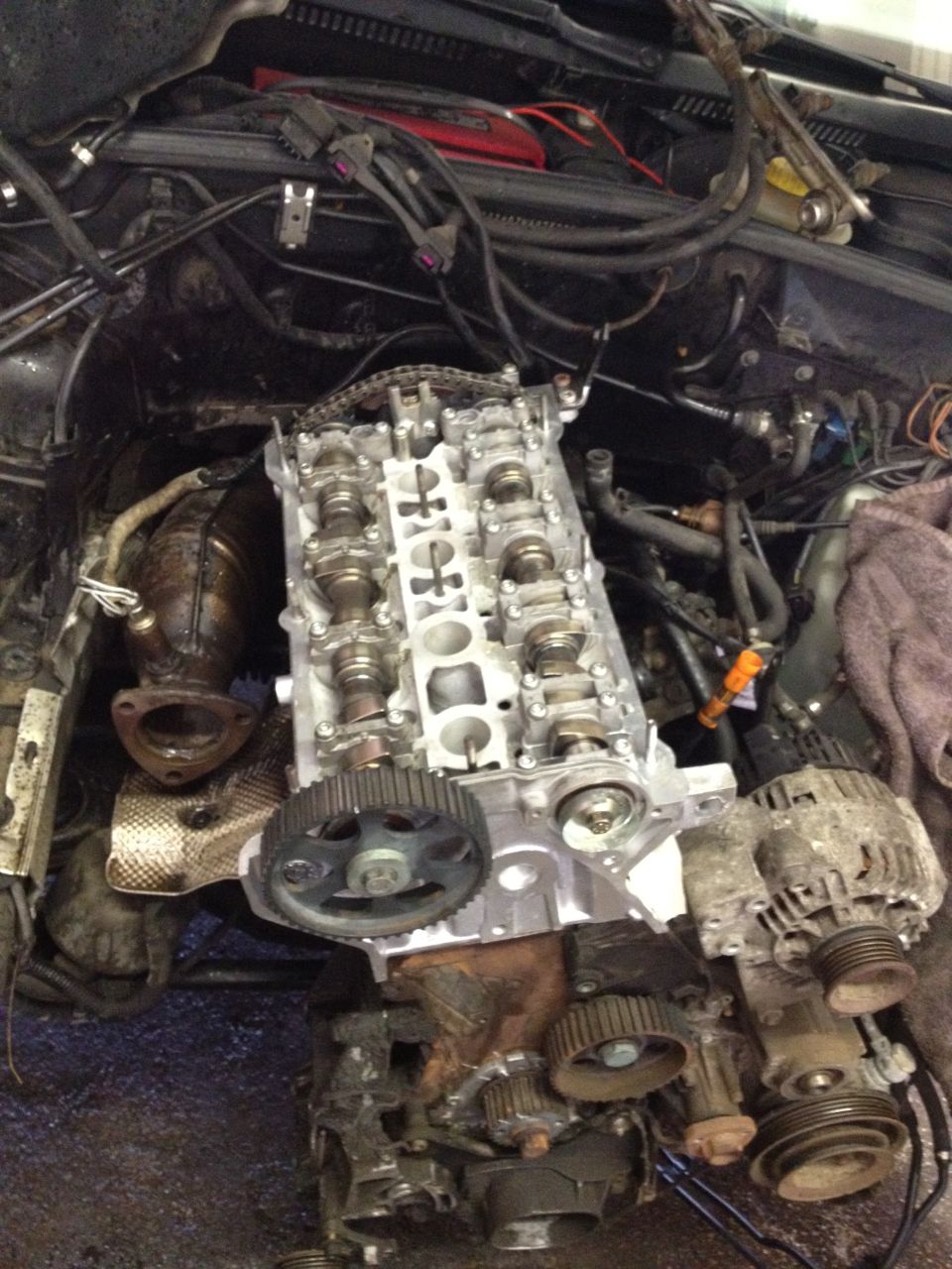 Engine block with camshafts, timing gears, and alternator removed from a vehicle