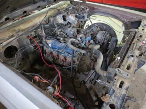 1989 Ford Bronco - The engine bay of a vehicle is shown with its engine and various components exposed, indicating it is not in operational condition.
