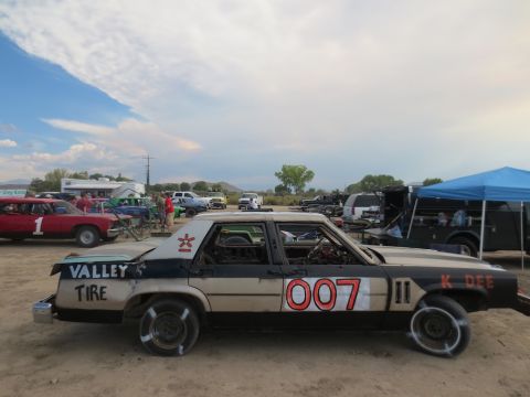 1989 Ford Bronco - A modified sedan, likely prepared for demolition derby, displays the number 007 and sponsor text on its exterior.