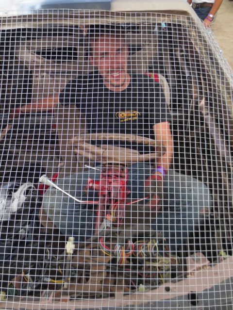 1989 Ford Bronco - A person smiles from inside a car's interior, which is covered by a protective wire mesh.