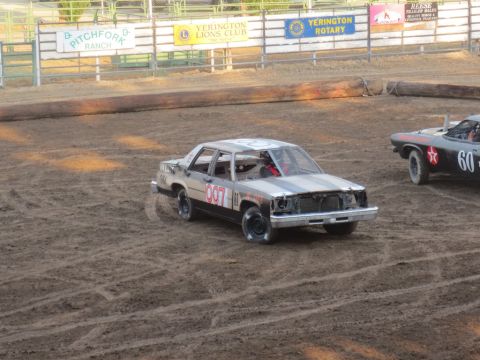 1989 Ford Bronco - A silver and gray striped sedan, marked with the number 007, participates in a demolition derby event.