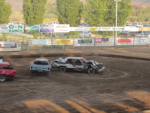 1989 Ford Bronco - Multiple cars compete in a demolition derby event on a dirt track.
