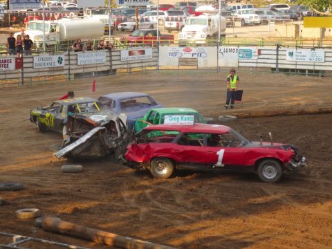 1989 Ford Bronco - Several cars are engaged in a demolition derby, with a red station wagon and a heavily damaged black car prominently featured.