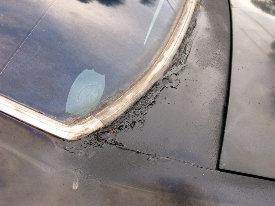 Corroded windshield seal on dark vehicle