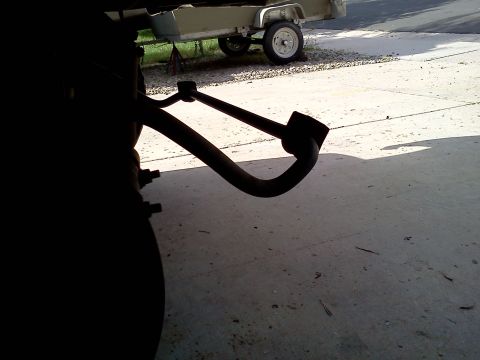 1995 Ford Bronco - A dark, silhouetted view focuses on a vehicle's suspension system, with a trailer visible in the background.