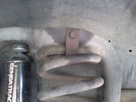 1995 Ford Bronco - Close-up view of a vehicle's suspension components, including a coil spring and shock absorber.