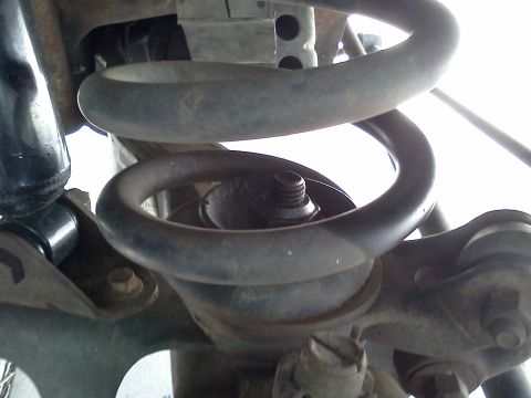 1995 Ford Bronco - Close-up view of the front coil spring and shock absorber assembly, likely from a truck or SUV.