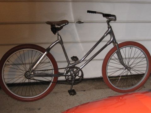 1994 Ford Bronco - A custom bicycle with a unique frame design and red tires is shown in a garage.