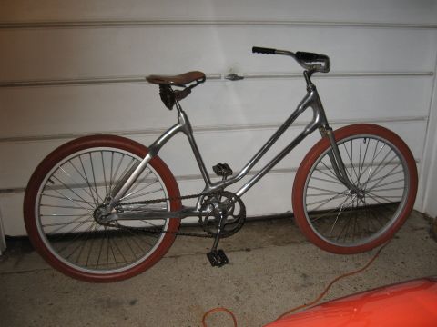 1994 Ford Bronco - Custom bicycle with silver frame and red tires parked in front of a garage door.