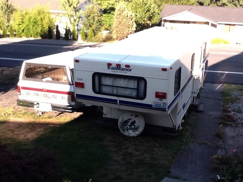 1988 Suzuki Samurai - A white Dodge pickup truck is seen towing a white Trail Manor camper trailer.