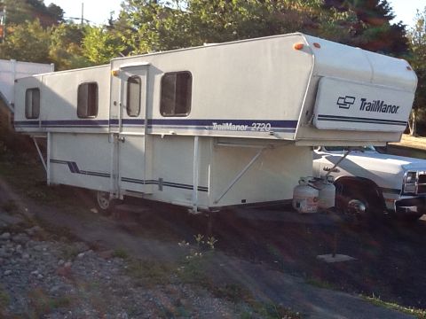 1988 Suzuki Samurai - This TrailManor 2720 truck camper is mounted on a white truck, seen from the side.