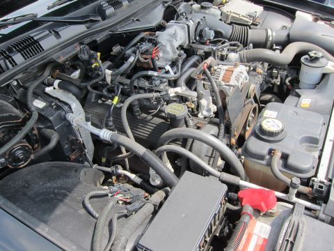 2001 Ford Crown Victoria - Close-up view of an engine bay, showing the complex arrangement of mechanical parts and wiring.