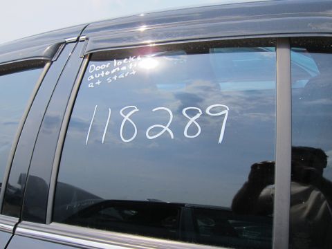 2001 Ford Crown Victoria - Handwritten notes and a number are visible on the tinted side window of a dark sedan.