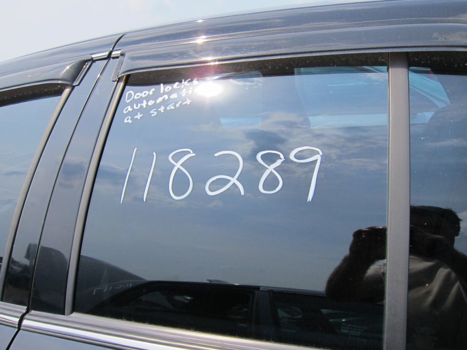 Dark sedan side window with "Door locks automatic & start" and "118289" written on it