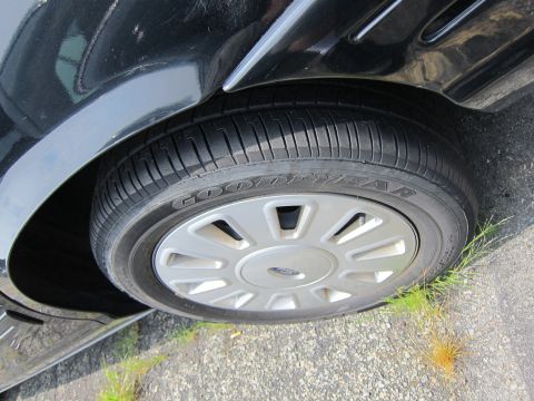 2001 Ford Crown Victoria - Front wheel and fender detail of a 2001 Ford Crown Victoria, a Goodyear tire and hubcap.