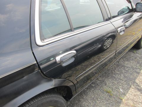 2001 Ford Crown Victoria - The side profile of a black 2001 Ford Crown Victoria, showing its distinctive body lines and chrome accents.